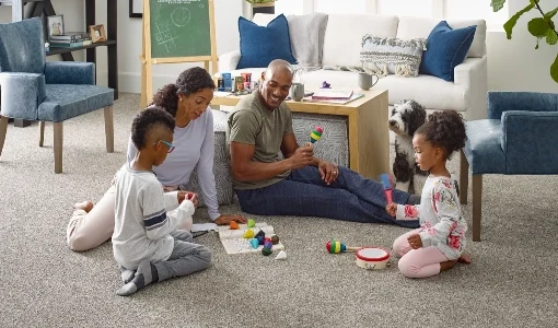 Family sitting down on carpeted floor playing