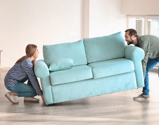 Couple moving a blue couch