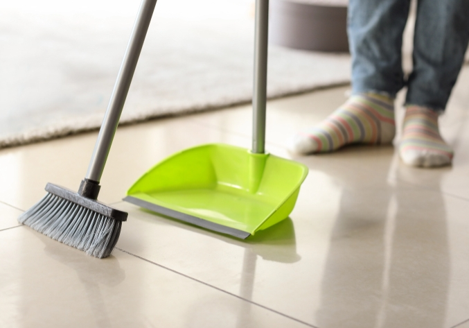 Person sweeping tile floors